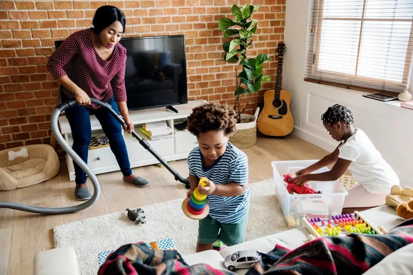 A woman and two children cleaning the floor.