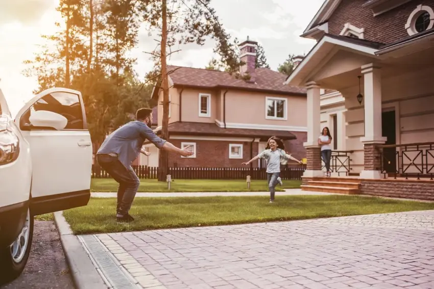 A man and woman playing frisbee in front of their home.