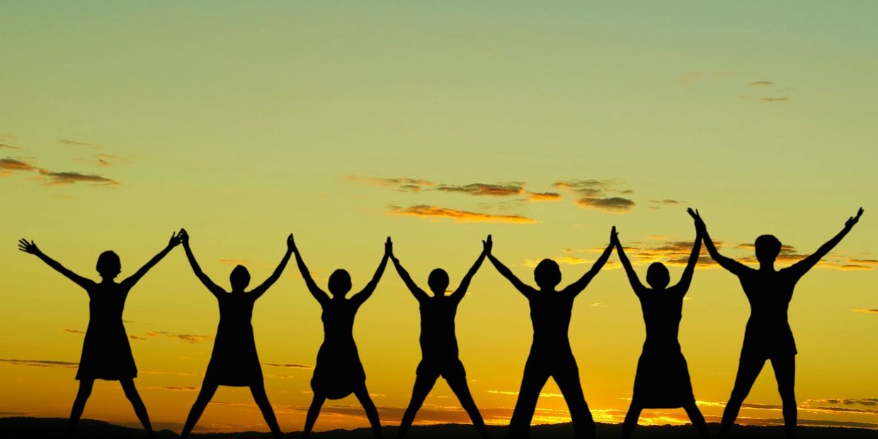 A group of people holding hands in the air.